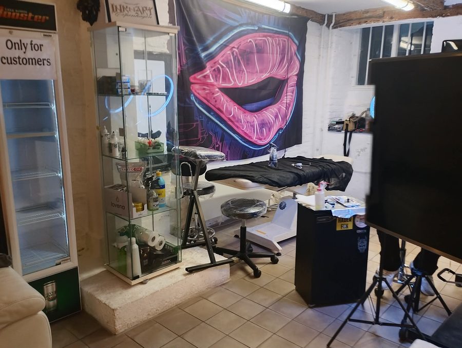 Tatovørstol med neon lips-banner hos Ink & Art Copenhagen