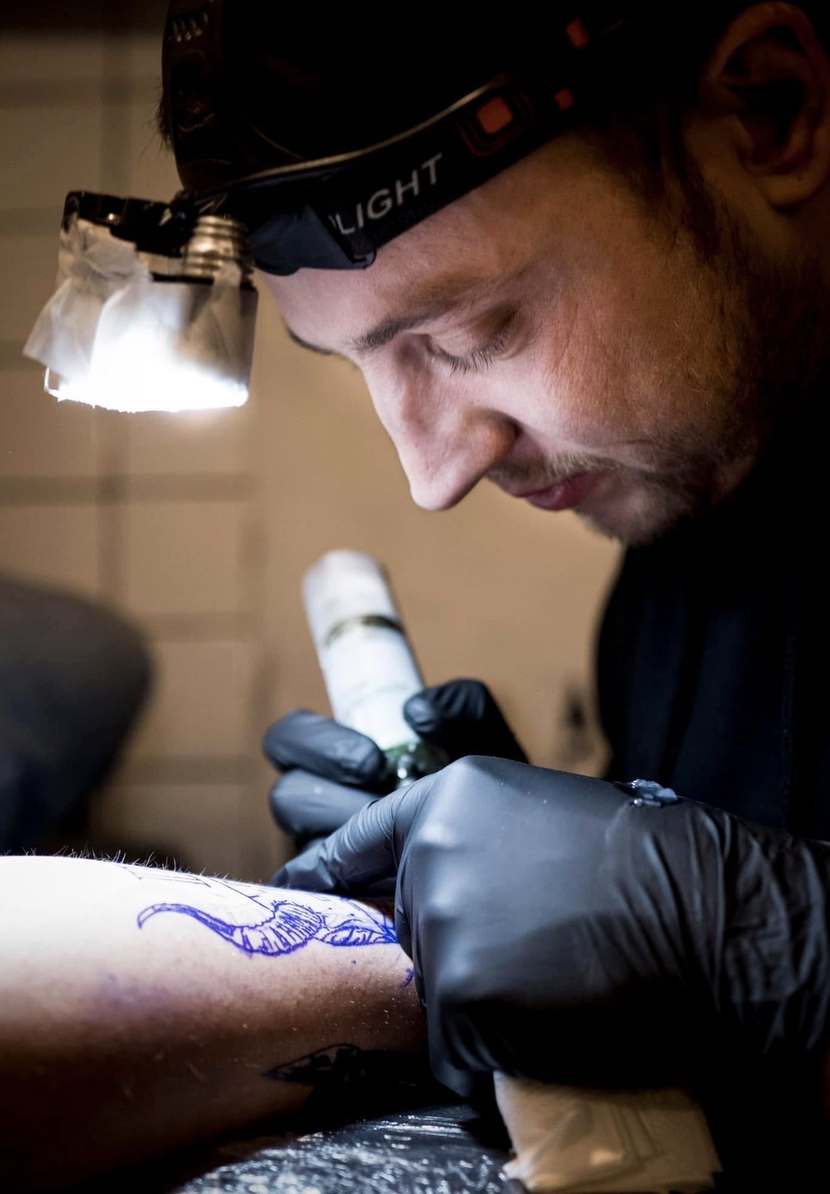 Nizar tatoverer under pandelampen hos Ink & Art