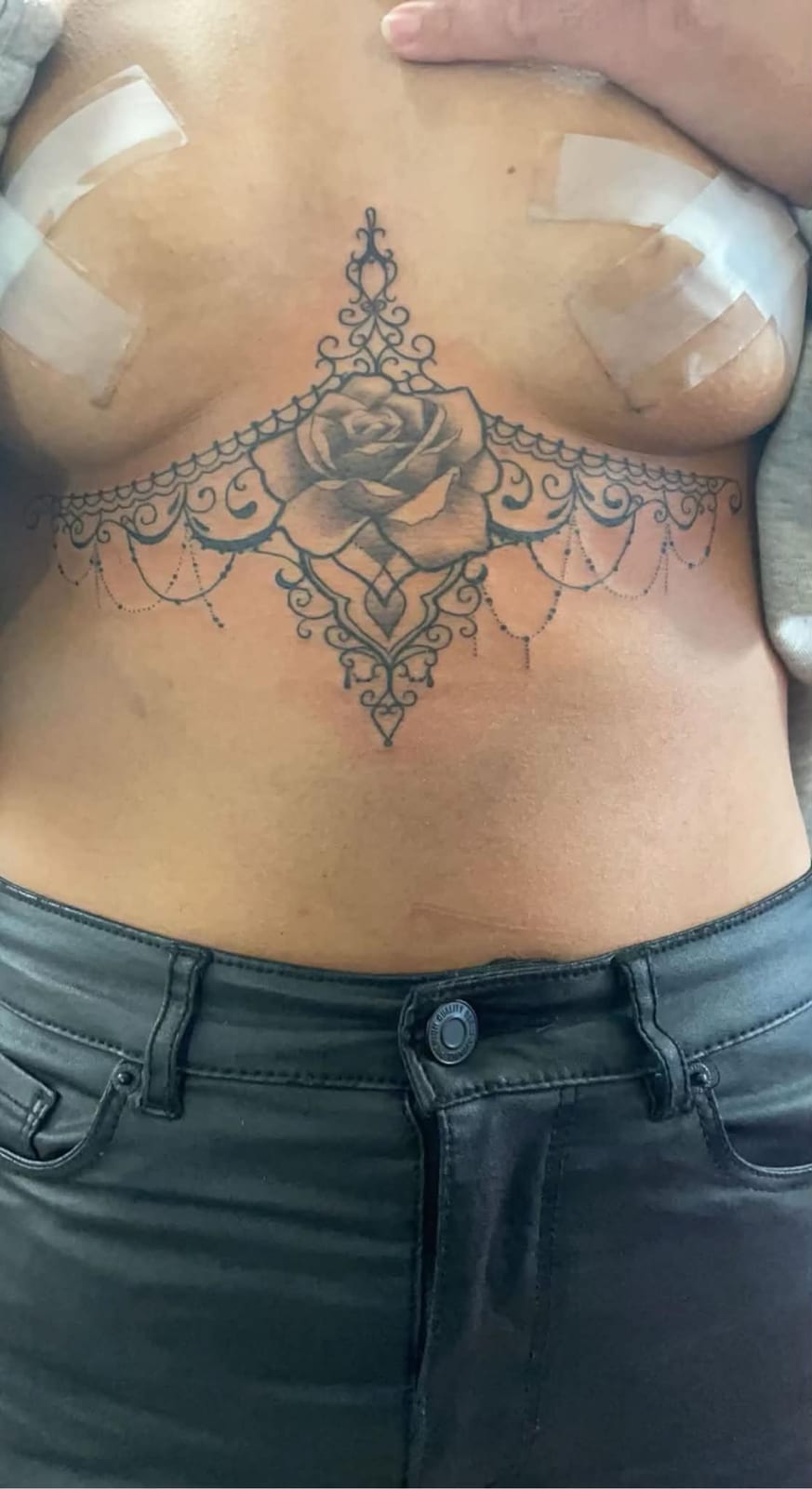 Rose med blondeværk og perlekæder, sort og gråt, under brystet.